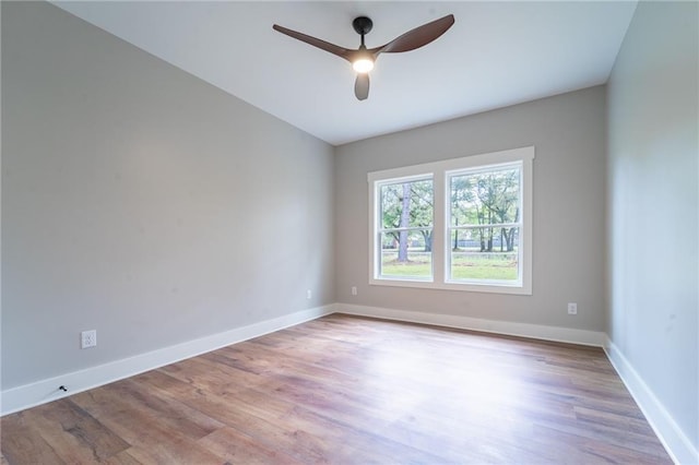 empty room with baseboards, ceiling fan, and wood finished floors