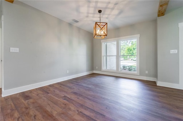 empty room with dark wood-type flooring, a chandelier, and visible vents