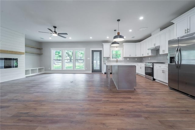 kitchen with open floor plan, white cabinets, stainless steel appliances, and ceiling fan