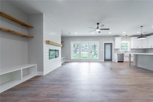 unfurnished living room featuring a fireplace, wood finished floors, recessed lighting, and a ceiling fan