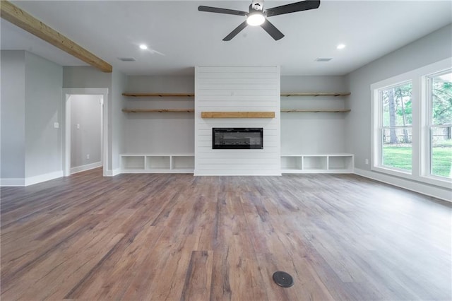 unfurnished living room featuring baseboards, visible vents, wood finished floors, and a ceiling fan