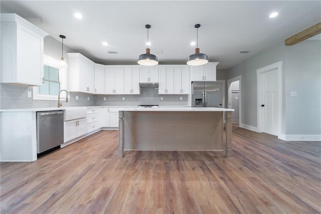 kitchen featuring white cabinetry, a sink, appliances with stainless steel finishes, and backsplash
