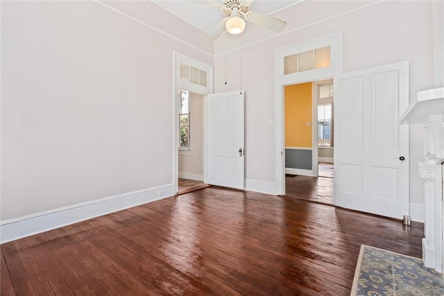 spare room featuring ceiling fan, a wealth of natural light, dark hardwood / wood-style flooring, and a towering ceiling