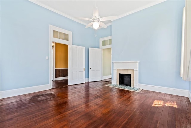 unfurnished living room with a towering ceiling, ceiling fan, crown molding, a tile fireplace, and dark hardwood / wood-style flooring