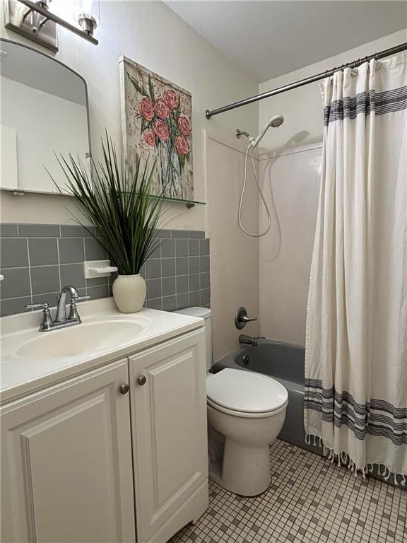 332 Syracuse St, Mobile, AL 36608 - full bathroom featuring toilet, shower / tub combo, vanity, tile patterned floors, and tasteful backsplash