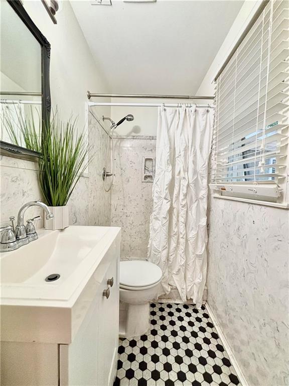 332 Syracuse St, Mobile, AL 36608 - full bath featuring a shower with shower curtain, toilet, vanity, and tile patterned floors