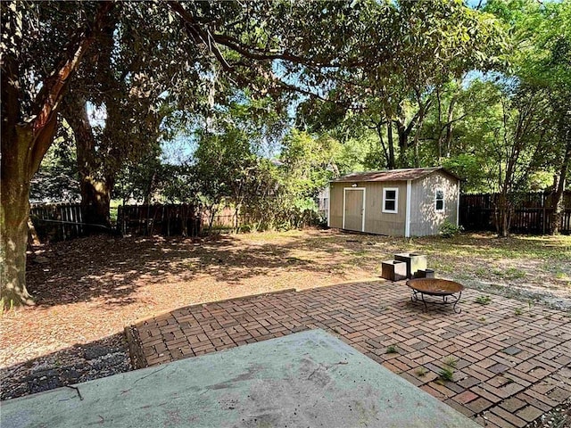 332 Syracuse St, Mobile, AL 36608 - view of patio / terrace with an outdoor fire pit, a fenced backyard, an outdoor structure, a storage shed, and view of scattered trees