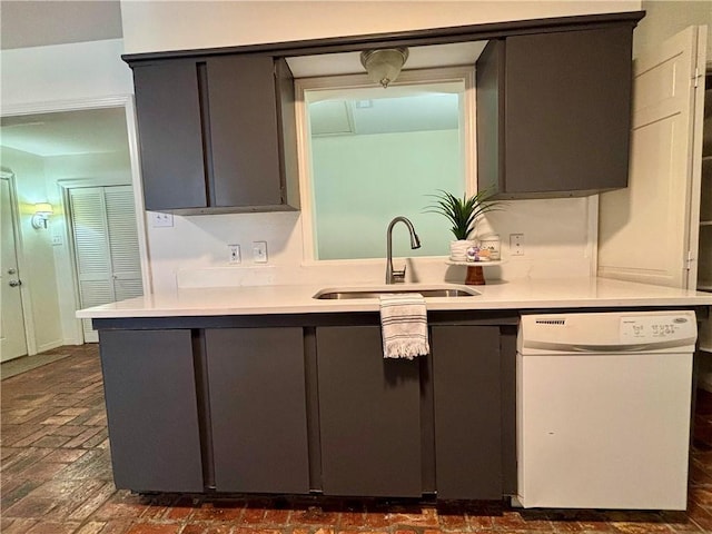 332 Syracuse St, Mobile, AL 36608 - kitchen with dishwasher, a sink, light countertops, brick flooring, and gray cabinets
