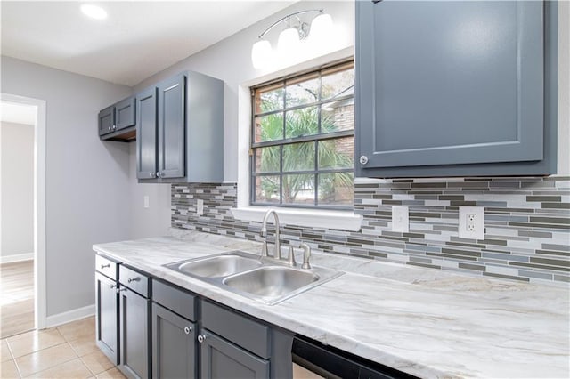 kitchen featuring light tile patterned floors, backsplash, stainless steel dishwasher, and sink