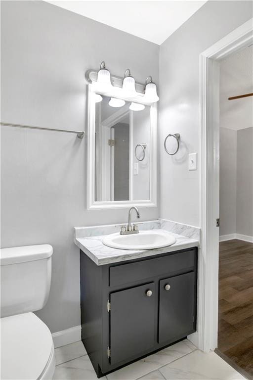 bathroom with hardwood / wood-style floors, vanity, and toilet