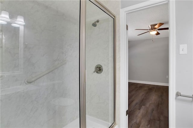 bathroom featuring wood-type flooring, a shower with door, and ceiling fan