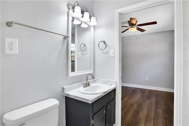 bathroom featuring wood-type flooring, vanity, toilet, and ceiling fan