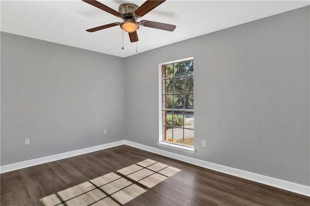 empty room with plenty of natural light, dark wood-type flooring, and ceiling fan