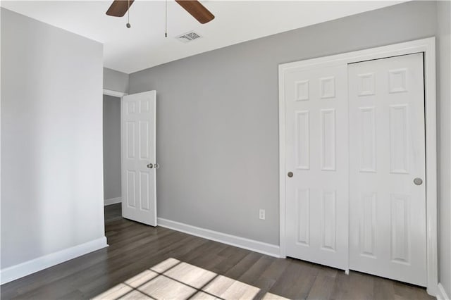 unfurnished bedroom featuring a closet, dark wood-type flooring, and ceiling fan