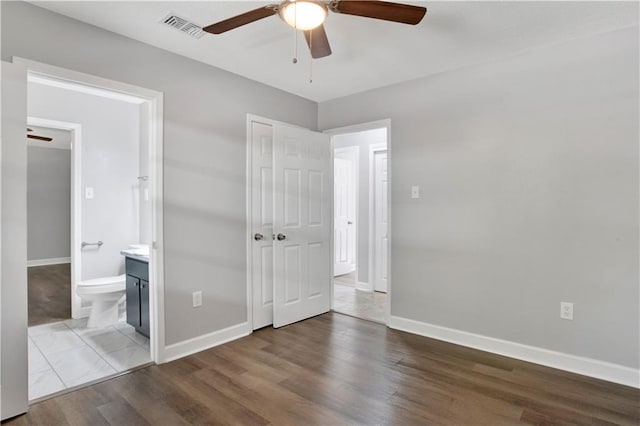 unfurnished bedroom featuring wood-type flooring, ensuite bath, and ceiling fan