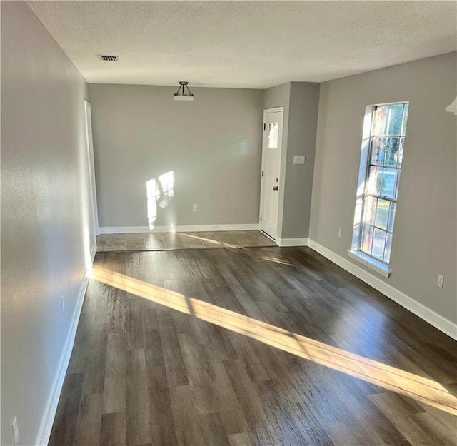 interior space with a textured ceiling and dark wood-type flooring