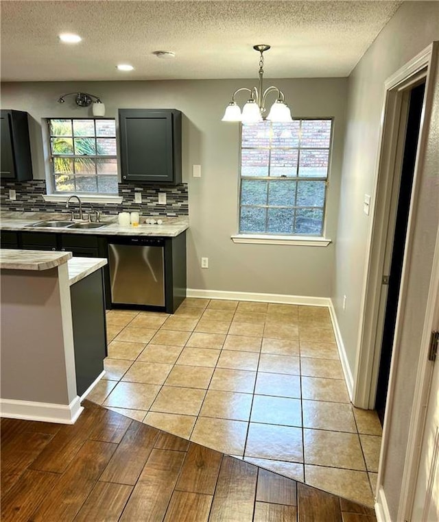 kitchen with backsplash, an inviting chandelier, sink, hanging light fixtures, and stainless steel dishwasher