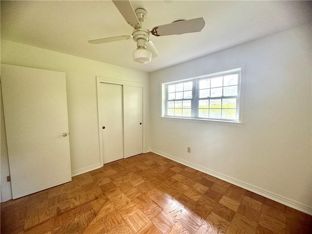 unfurnished bedroom featuring ceiling fan, a closet, and baseboards