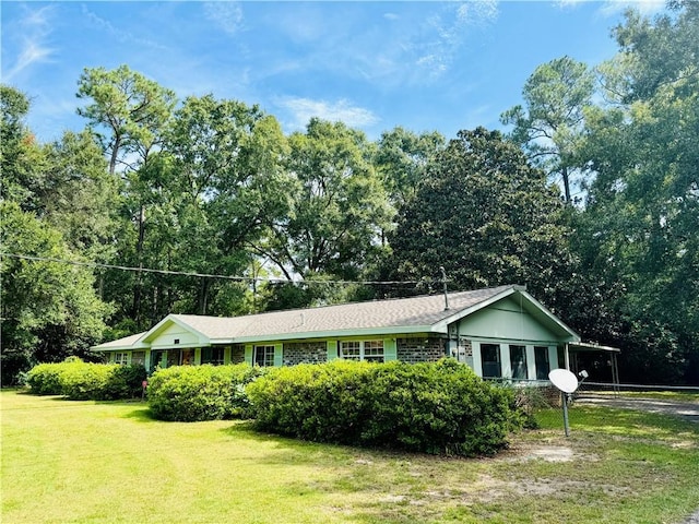 ranch-style home featuring an attached carport, brick siding, and a front lawn