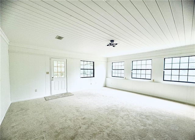 carpeted empty room with ornamental molding and visible vents