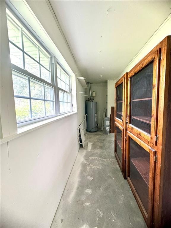 corridor with concrete floors and gas water heater