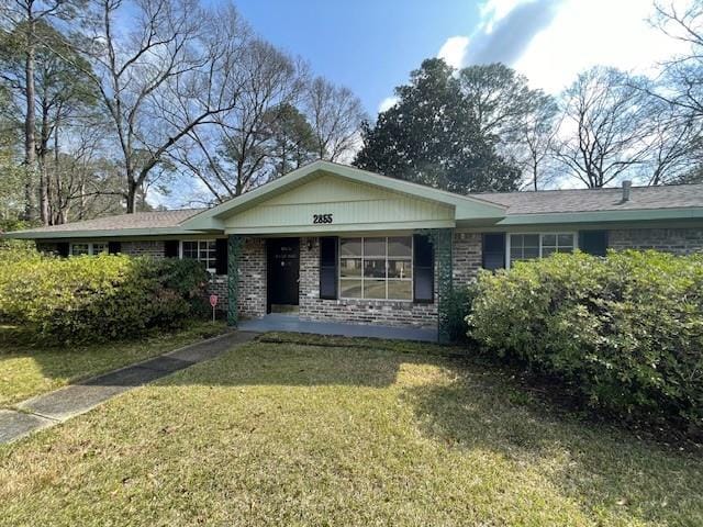 single story home with brick siding and a front lawn