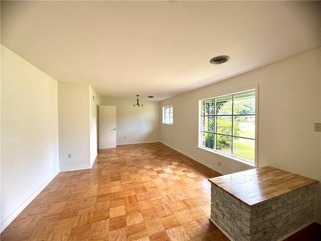 unfurnished room with visible vents and baseboards