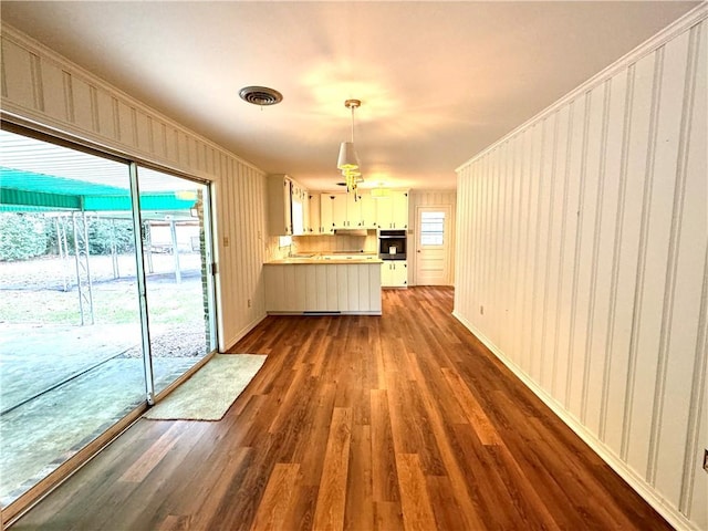 interior space with visible vents, ornamental molding, and dark wood-type flooring