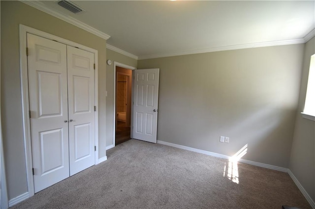 unfurnished bedroom featuring light colored carpet, a closet, and crown molding