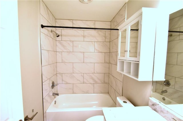 bathroom with toilet and tiled shower / bath