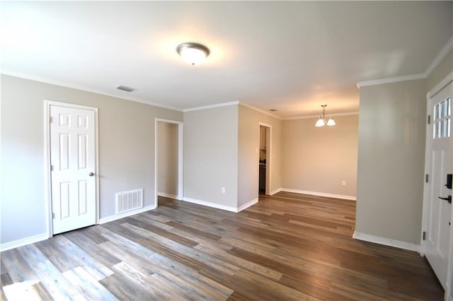 unfurnished room featuring ornamental molding, dark wood-type flooring, and a notable chandelier