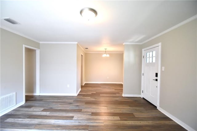 foyer featuring dark hardwood / wood-style floors, crown molding, and a notable chandelier