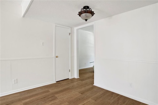 4017 Cottage Hill Rd Unit 17, Mobile, AL 36609 - spare room featuring a textured ceiling, wood finished floors, a wainscoted wall, and a decorative wall