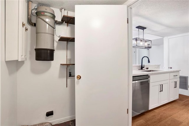 4017 Cottage Hill Rd Unit 17, Mobile, AL 36609 - kitchen featuring stainless steel dishwasher, wood finished floors, white cabinets, light countertops, and a textured ceiling