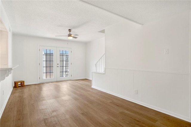 4017 Cottage Hill Rd Unit 17, Mobile, AL 36609 - unfurnished living room with wood finished floors, ceiling fan, wainscoting, french doors, and a textured ceiling