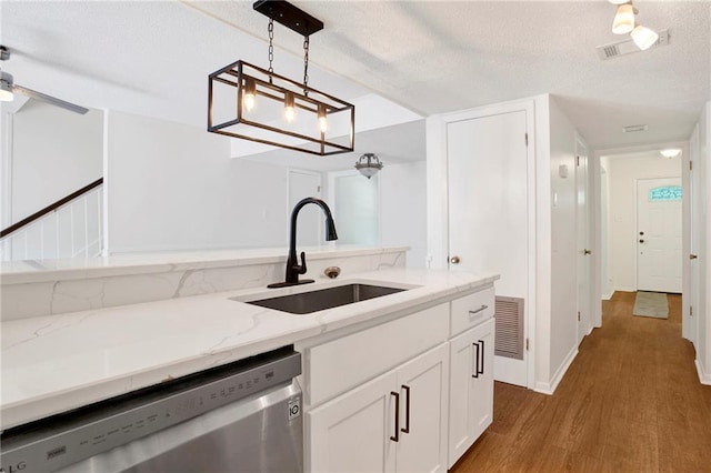 4017 Cottage Hill Rd Unit 17, Mobile, AL 36609 - kitchen with stainless steel dishwasher, wood finished floors, light stone countertops, white cabinetry, and pendant lighting