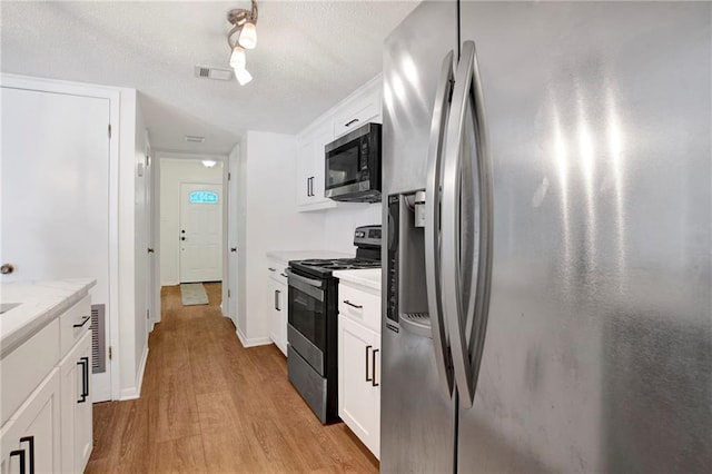 4017 Cottage Hill Rd Unit 17, Mobile, AL 36609 - kitchen with stainless steel appliances, light wood-style flooring, light countertops, white cabinets, and a textured ceiling