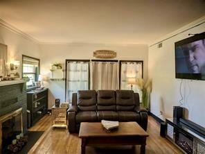 living room with wood-type flooring and ornamental molding