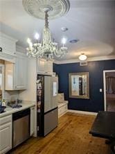 kitchen featuring white cabinetry, dark wood-type flooring, a chandelier, and appliances with stainless steel finishes