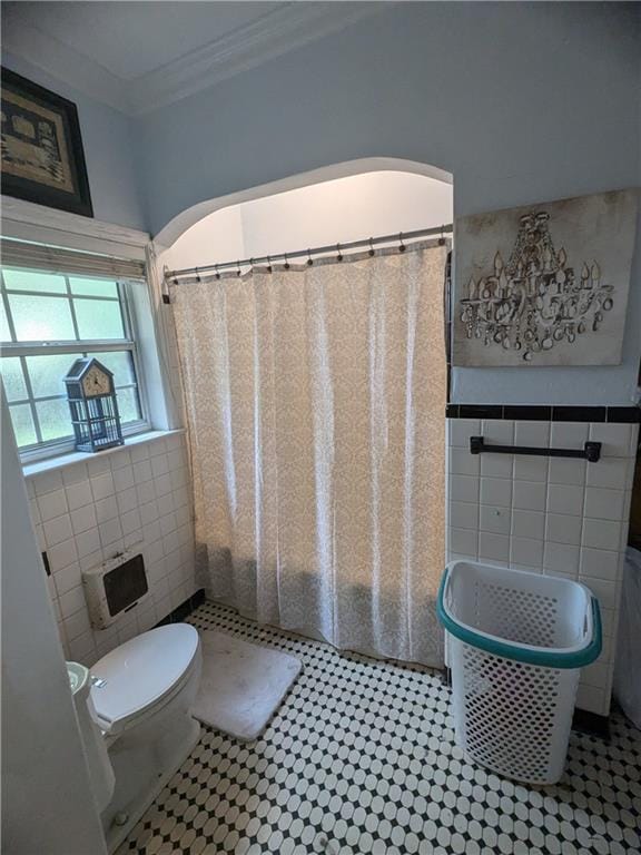 bathroom with toilet, ornamental molding, tile walls, walk in shower, and heating unit