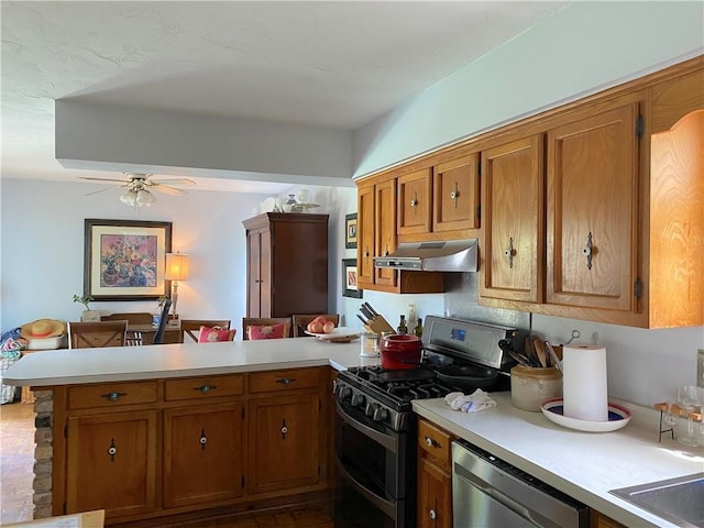 kitchen with appliances with stainless steel finishes, kitchen peninsula, ceiling fan, and sink