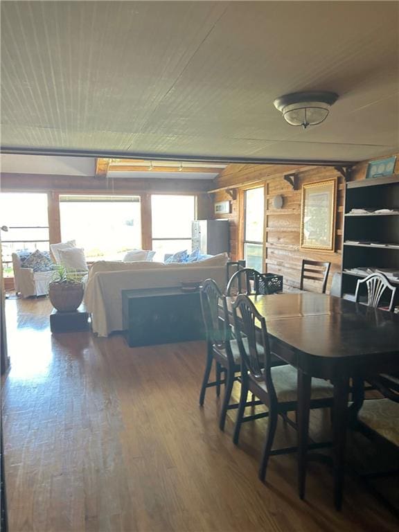 dining room featuring wood-type flooring and wooden walls