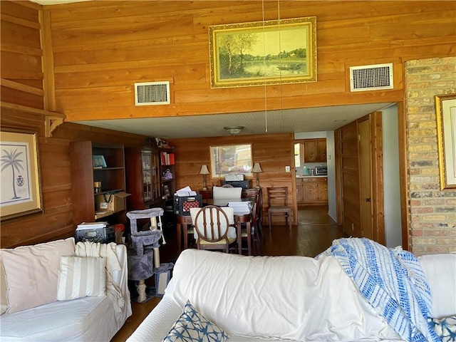 living room featuring wood walls and dark wood-type flooring