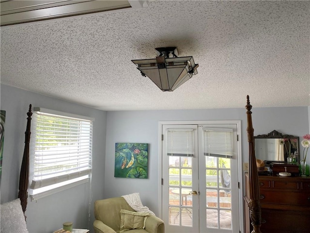 living area featuring french doors and a textured ceiling