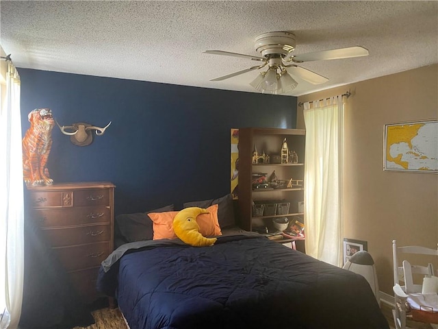 bedroom with a textured ceiling and ceiling fan