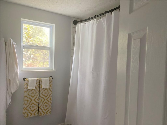 bathroom with a textured ceiling and curtained shower