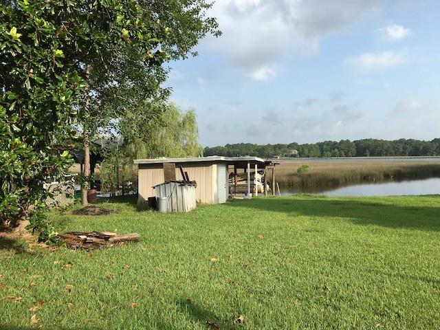 view of yard with a shed and a water view