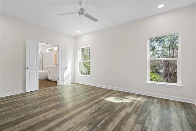 unfurnished bedroom with dark hardwood / wood-style flooring, ceiling fan, and connected bathroom