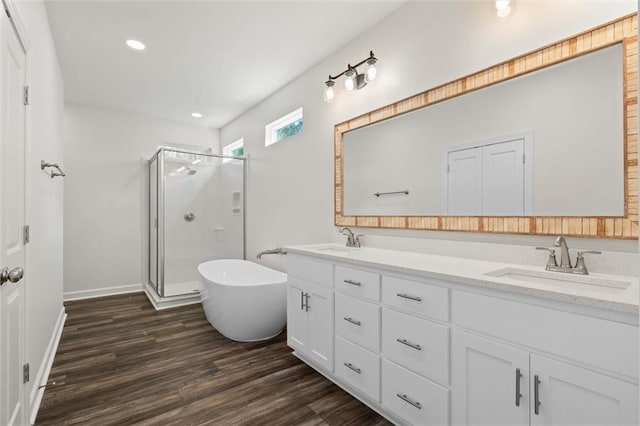 bathroom featuring wood-type flooring, plus walk in shower, and vanity