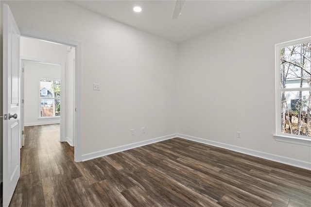 unfurnished room featuring ceiling fan, plenty of natural light, and dark wood-type flooring